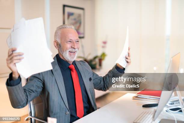 cheerful mature businessman celebrating in office. - managing director office stock pictures, royalty-free photos & images
