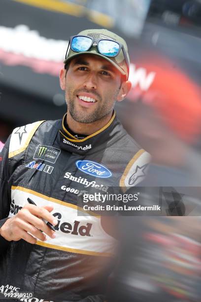 Aric Almirola, driver of the Smithfield Ford, walks to his car during practice for the NASCAR Xfinity Series Coca-Cola Firecracker 250 at Daytona...