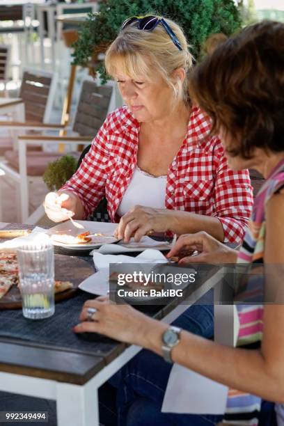 vriendinnen pizza eten in café - bakibg stockfoto's en -beelden