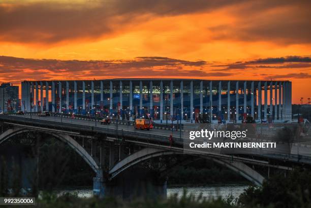 Picture taken on July 5, 2018 shows the Nizhny Novgorod stadium at sunset situated behind the cathedral of Alexander Nevskiy in the city of Nizhny...