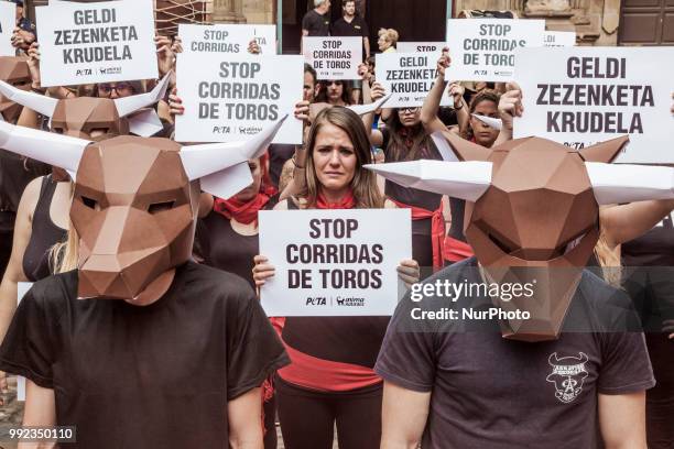 Protest against animal cruelty in bull fightings before San Fermin celebrations in Pamplona, Spain. Banner says &quot;stop bullfightings&quot; and...