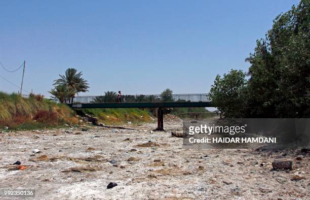 This picture shows an empty riverbed in Umm Abbasiyat, some 60 kilometers east of Najaf, on July 5, 2018. - Beyond this year's dramatic lack of rain,...