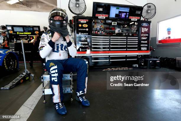 Brad Keselowski, driver of the Stars Stripes and Lites Ford, sits in the garage area during practice for the Monster Energy NASCAR Cup Series Coke...