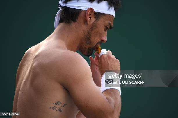 Italy's Fabio Fognini eats an energy snack while playing Italy's Simone Bolelli in their men's singles second round match on the fourth day of the...