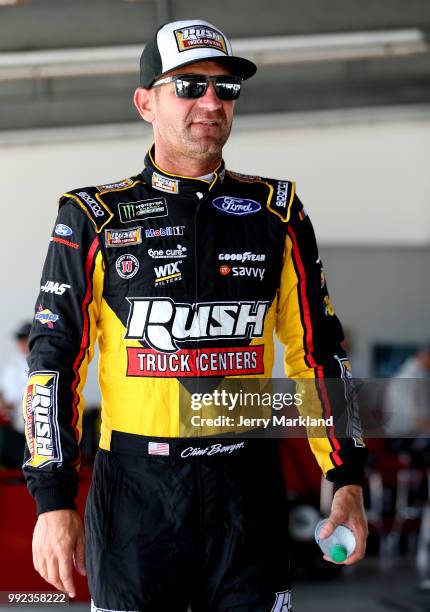 Clint Bowyer, driver of the Rush Truck Centers Ford, stands in the garage area during practice for the Monster Energy NASCAR Cup Series Coke Zero...