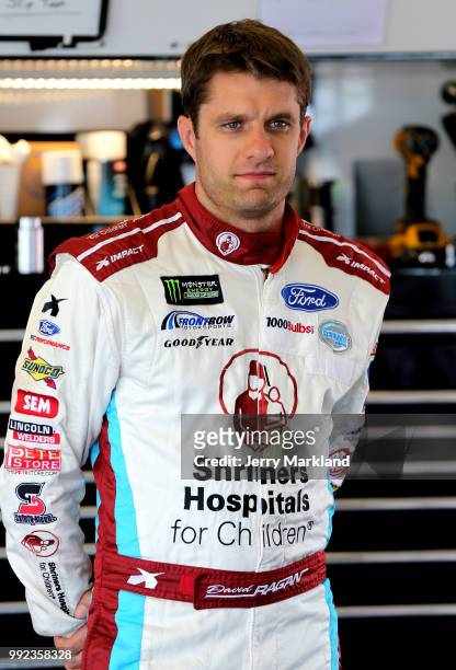 David Ragan, driver of the Shriners Hospital For Children Ford, stands in the garage during practice for the Monster Energy NASCAR Cup Series Coke...