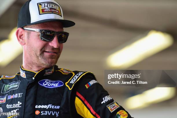 Clint Bowyer, driver of the Rush Truck Centers Ford, stands in the garage during practice for the Monster Energy NASCAR Cup Series Coke Zero Sugar...