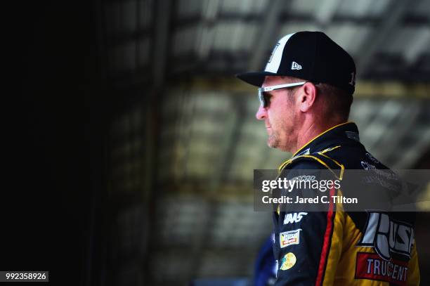 Clint Bowyer, driver of the Rush Truck Centers Ford, stands in the garage during practice for the Monster Energy NASCAR Cup Series Coke Zero Sugar...