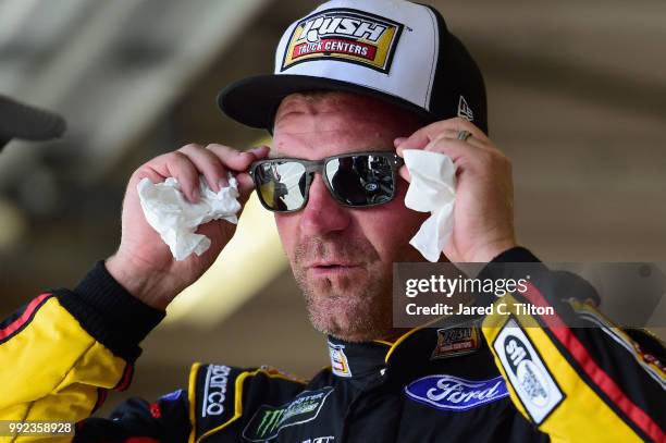 Clint Bowyer, driver of the Rush Truck Centers Ford, stands in the garage during practice for the Monster Energy NASCAR Cup Series Coke Zero Sugar...