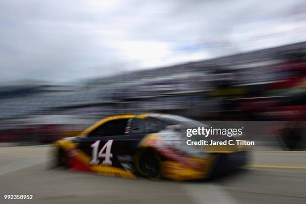 Clint Bowyer, driver of the Rush Truck Centers Ford, drives through the garage area during practice for the Monster Energy NASCAR Cup Series Coke...