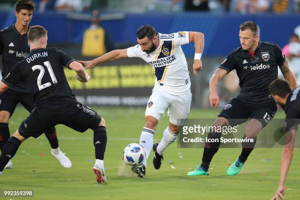 Los Angeles Galaxy midfielder Romain Alessandrini gets off a near perfect pass between defenders in D.C. United defender Frederic Brillant D.C....