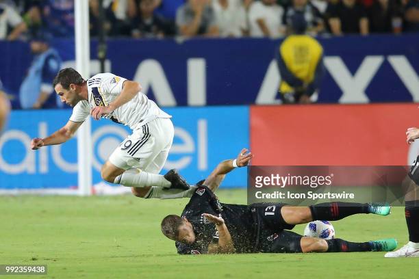 Los Angeles Galaxy forward Chris Pontius goes flying after being stripped of the ball with a sliding tackle by D.C. United defender Frederic Brillant...