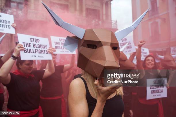 Members of the PETA collective with masks of bulls and banners during their protest in the Plaza del Ayuntamiento in Pamplona for the feast of San...