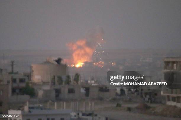 This picture shows an explosion in rebel-held areas of the city of Daraa during reported airstrikes by Syrian regime forces on July 5, 2018. Waves of...