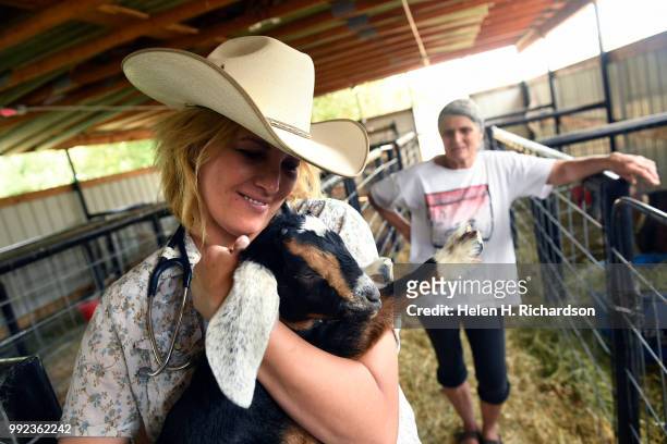 Veterinarian Dr. Romy Nicoletta gives Prince, a baby goat, a hug after checking on goats at Huerfano County Fairgrounds during the Spring Creek Fire...