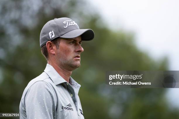 Webb Simpson walks to his second shot on the 12th hole during round one of A Military Tribute At The Greenbrier held at the Old White TPC course on...