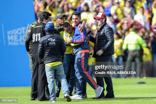 Colombian national team player Radamel Falcado is embraced by a fan during the welcoming ceremony of the team at El Campin stadium in Bogota on July...