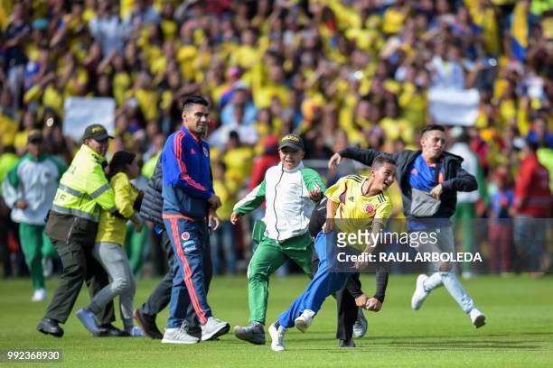Colombian national team player Radamel Falcado walks as fans are chased by police during the welcoming ceremony of the team at El Campin stadium in...