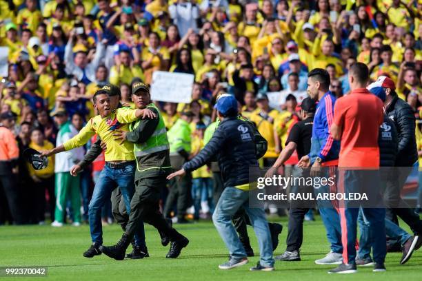 Colombian national team player Radamel Falcado walks as fans are stopped by police as they enter the field during the welcoming ceremony of the team...