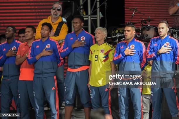 Colombian national team coach Jose Pekerman stands next to players singing the national anthem during their welcoming ceremony at El Campin stadium...