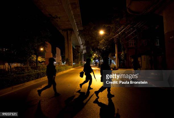 Thai soldiers cross a deserted street in the central business district on May 13, 2010 in central Bangkok, Thailand. The Black Shirt Guards are used...