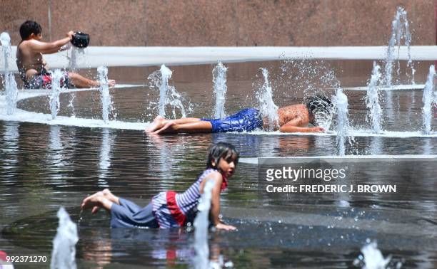 Children cool off in the water play area at Grand Park in Los Angeles, California on July 5, 2018 ahead of a coming heatwave in the Los Angeles area.