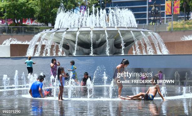 Children cool off in the water play area at Grand Park in Los Angeles, California on July 5, 2018 ahead of a coming heatwave in the Los Angeles area.