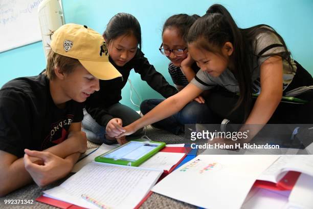 Volunteer youth counselor Connor Jones left, helps Sarah second from left, Sher Deh, 11 and Yeh Doh right, work on making their Write Our Word ebook...