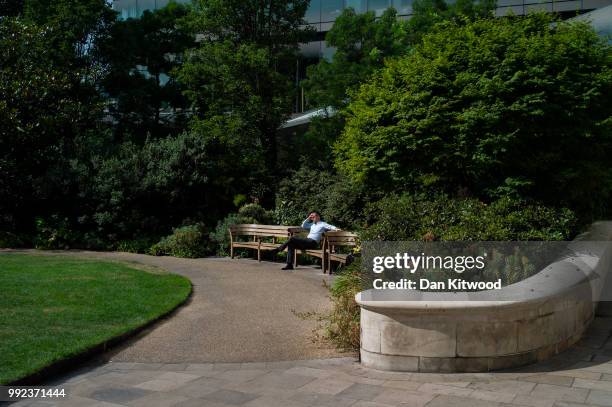 Man relaxes in a park near St Paul's Cathedral on July 5, 2018 in London, England. A prolonged heatwave continues to grip much of the country, with...