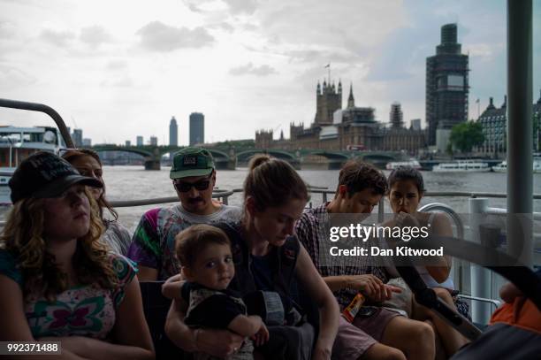 Members of the public take the ferry up the Thames past the Houses of Parliament on July 5, 2018 in London, England. A prolonged heatwave continues...