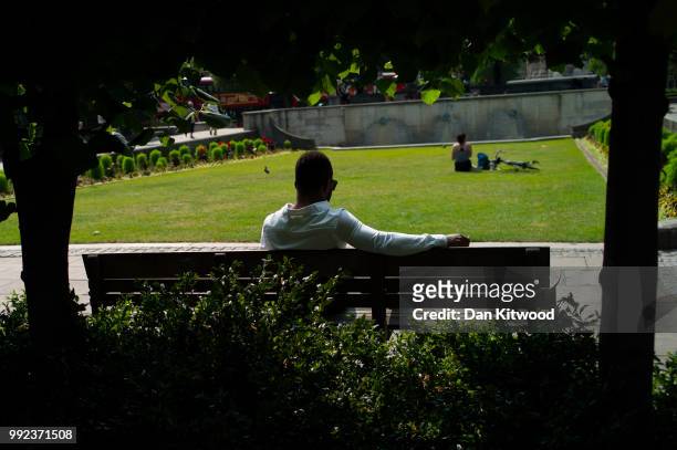 Man relaxes in a park near St Paul's Cathedral on July 5, 2018 in London, England. A prolonged heatwave continues to grip much of the country, with...
