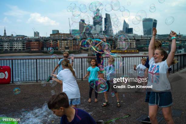 Children play with bubbles on the South Bank on July 5, 2018 in London, England. A prolonged heatwave continues to grip much of the country, with no...