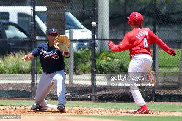Clearwater, FL Ray Hernandez of the Braves waits for the throw as Phillies runner Juan Aparicio hustles down to first base during the Gulf Coast...