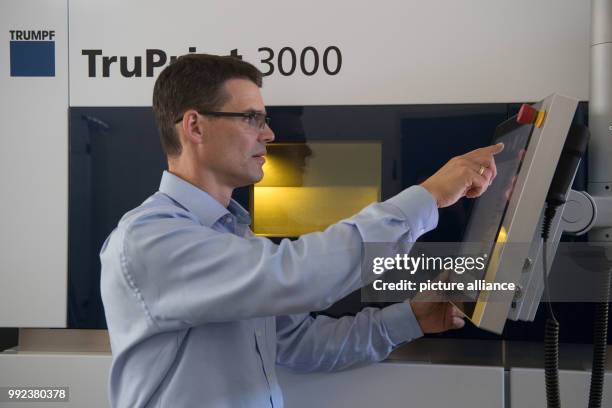 An employee operates a 3D printing machine where a component is produced out of metall powder at the 3D printing application centre of the machine...