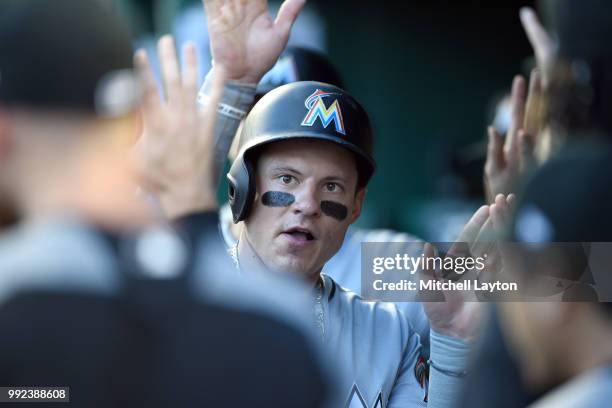 Derek Dietrich of the Miami Marlins celebrates scoring on a single by R.T. Realmuto in the second inning during a baseball game against the...
