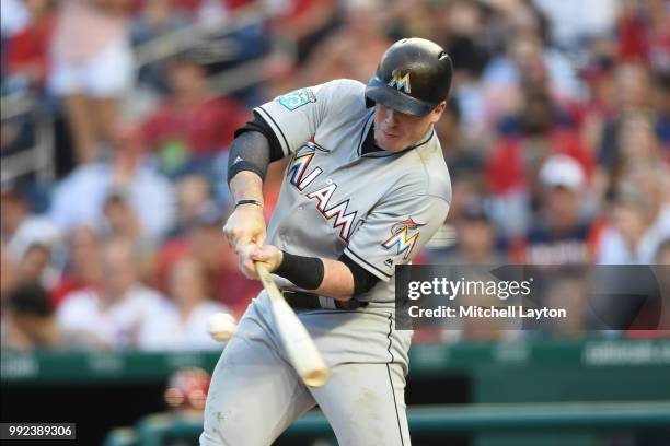 Justin Bour of the Miami Marlins singles in a run in the second inning during a baseball game against the Washington Nationals at Nationals Park on...