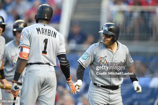 Martin Prado of the Miami Marlins celebrates a three run home with Corbin Maybin in the second inning during a baseball game against the Washington...