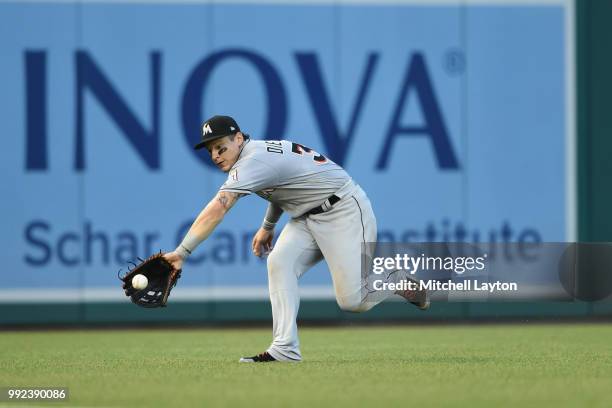 Derek Dietrich of the Miami Marlins tries to catch a Matt Adams of the Washington Nationals single in the third inning during a baseball game at...