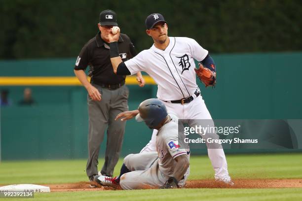 Jose Iglesias of the Detroit Tigers turns a first inning double play behind the slide of Delino DeShields of the Texas Rangers at Comerica Park on...