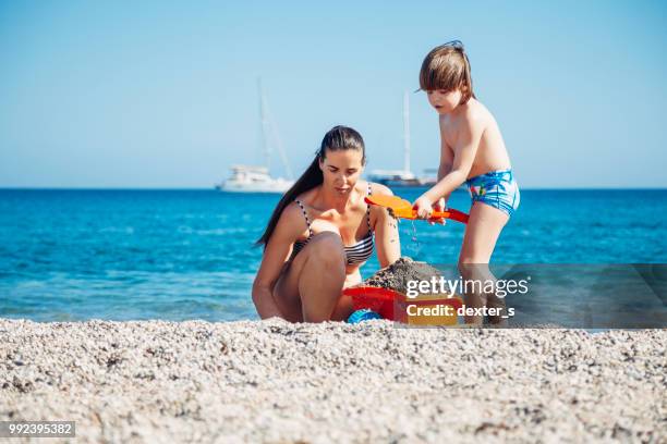 mother and son playing with toys at beach - dexters stock pictures, royalty-free photos & images