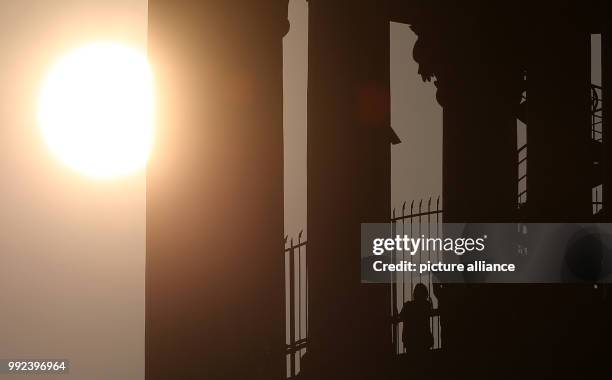 The tower of the St. Michaelis Church can be seen against the sunlight in Hamburg, Germany, 17 October 2017. The sun has appeared in a reddish orange...