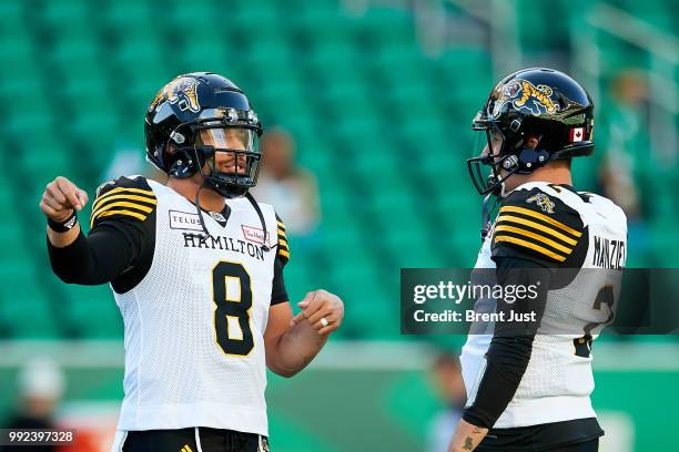 Jeremiah Masoli and Johnny Manziel of the Hamilton Tiger-Cats talk on the field during pregame warmup before the game between the Hamilton Tiger-Cats...