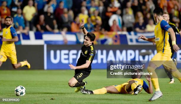 Nicosia's Lorenzo Ebecilio Dortmund's Marc Bartra vie for the ball during the Champions League group stages qualification match between APOEL Nicosia...