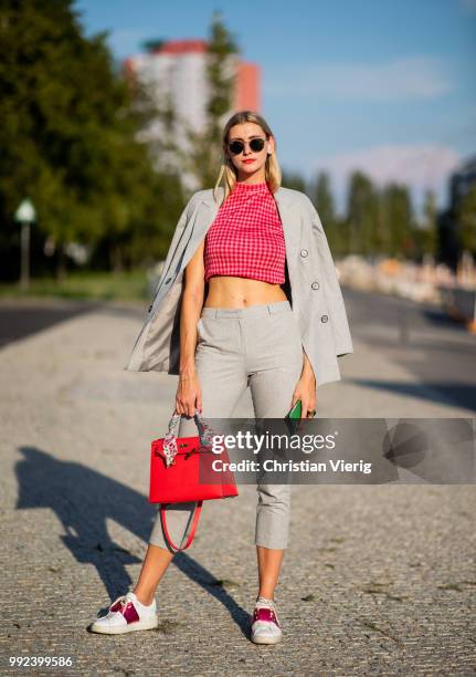 Kimyana Hachmann wearing grey cropped pants, red Hermes bag, grey jacket, cropped top is seen outside Dawid Tomaszewski during the Berlin Fashion...