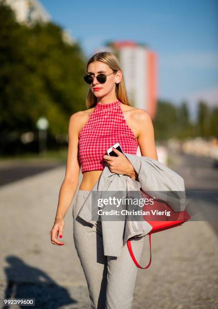 Kimyana Hachmann wearing grey cropped pants, red Hermes bag, grey jacket, cropped top is seen outside Dawid Tomaszewski during the Berlin Fashion...