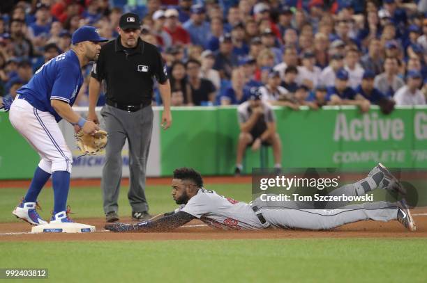 Niko Goodrum of the Detroit Tigers slides safely into third base as he hits a triple in the tenth inning during MLB game action as Kendrys Morales of...