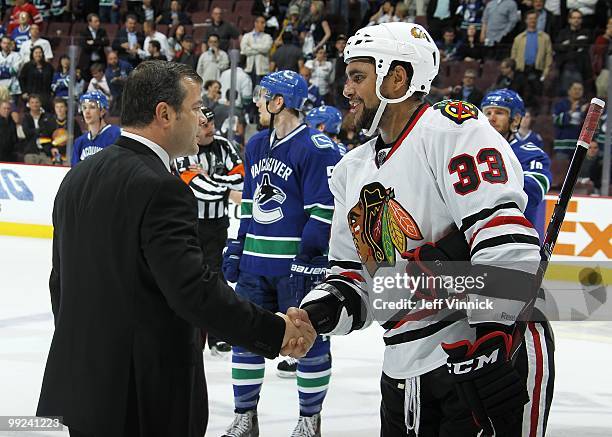 Head coach Alain Vigneault of the Vancouver Canucks shakes hands with Dustin Byfuglien of the Chicago Blackhawks in Game 6 of the Western Conference...
