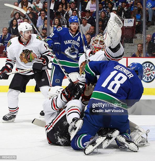 Henrik Sedin and Steve Bernier of the Vancouver Canucks and Brent Sopel of the Chicago Blackhawks look on as Antti Niemi of the Chicago Blackhawks...