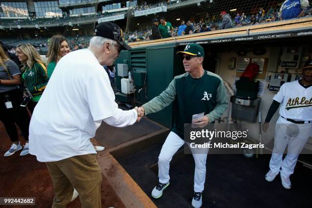 Medal of Honor winner from World War II shakes hands with Manager Bob Melvin of the Oakland Athletics in the during prior to the game between the...