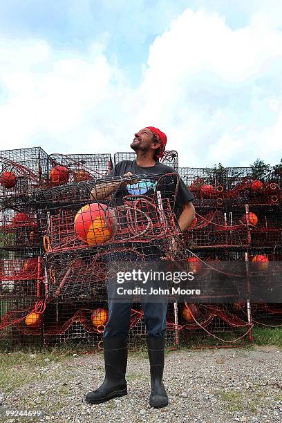 Crab trap builder Shawn Platt looks to a passing emergency helicopter while moving an idle trap in on May 13, 2010 in Hopedale, Louisiana. The traps...